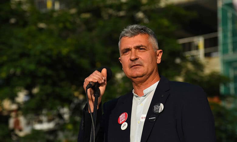 Политичар говори у мегафону на јавном окупљању.