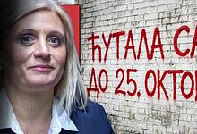Слика жене испред графита са натписом у позадини.