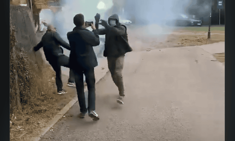 Група људи на улици са смеђом балонима димом у позадини.