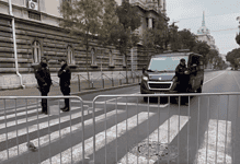 Вид блокиране улице са металним барикадама и полицијским службеницима.