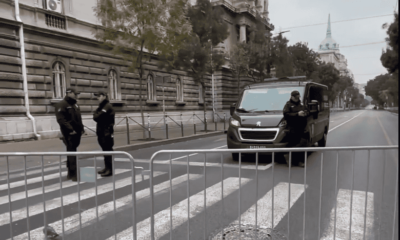 Вид блокиране улице са металним барикадама и полицијским службеницима.