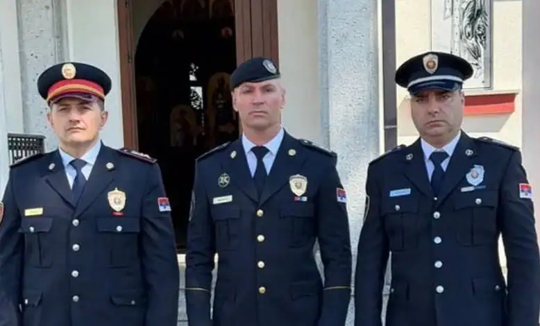 Три полицијска службеника стоје испред зграде.