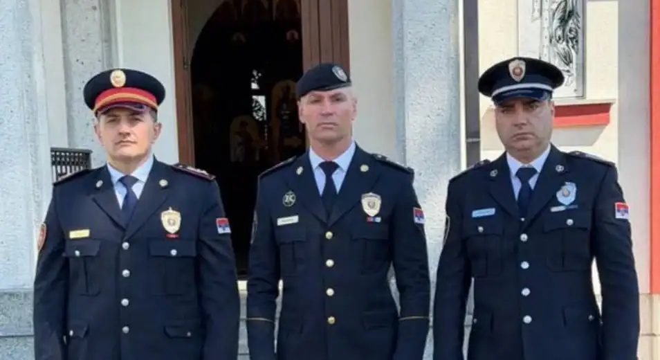 Три полицијска службеника стоје испред зграде.
